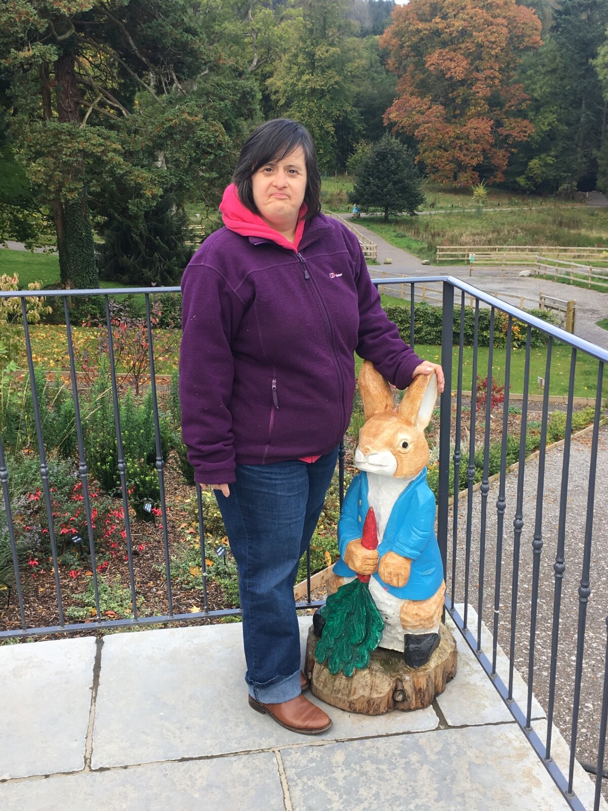 A resident posing beside a Peter Rabbit figure on an outing