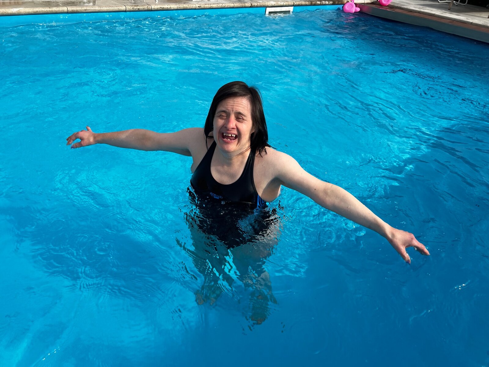 A resident swimming happily in an outdoor pool