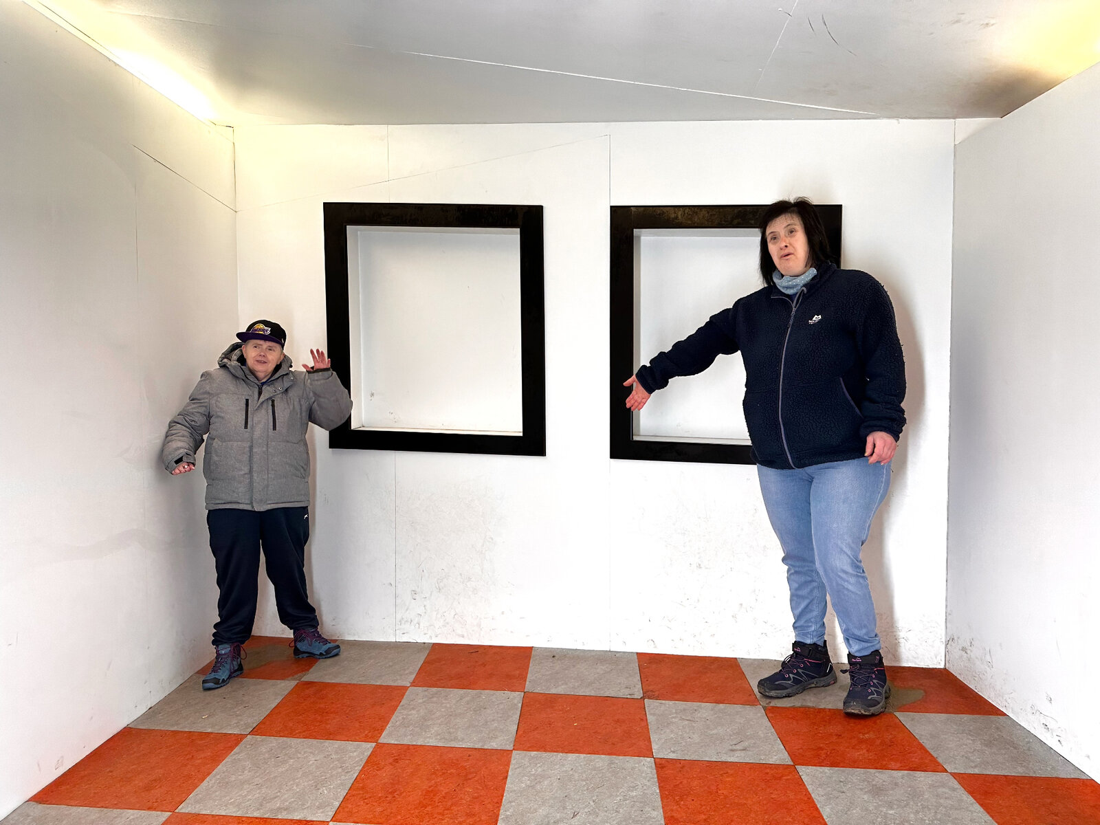 Residents enjoying an Ames room optical illusion attraction