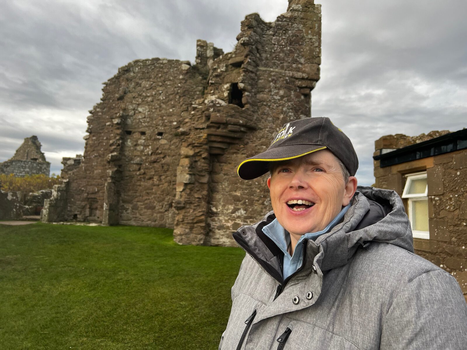 A resident smiling in front of historic Scottish castle ruins