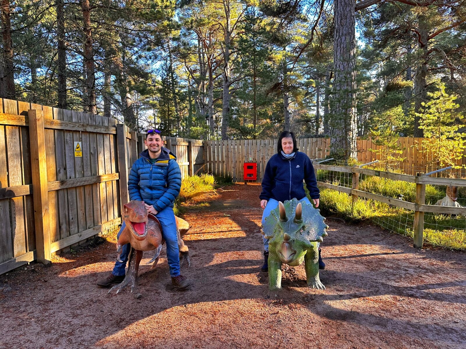 Residents enjoying a visit to a dinosaur park in the woods