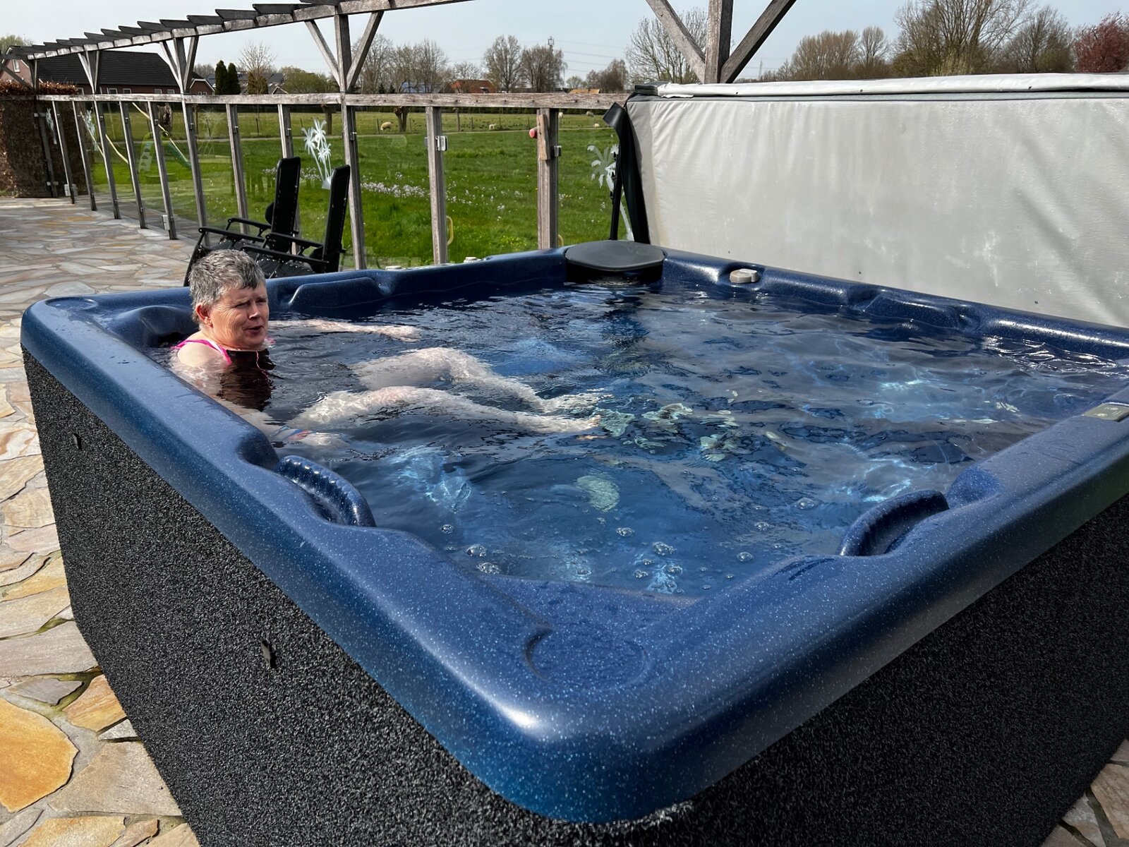 A resident enjoying a relaxing outdoor hot tub on holiday