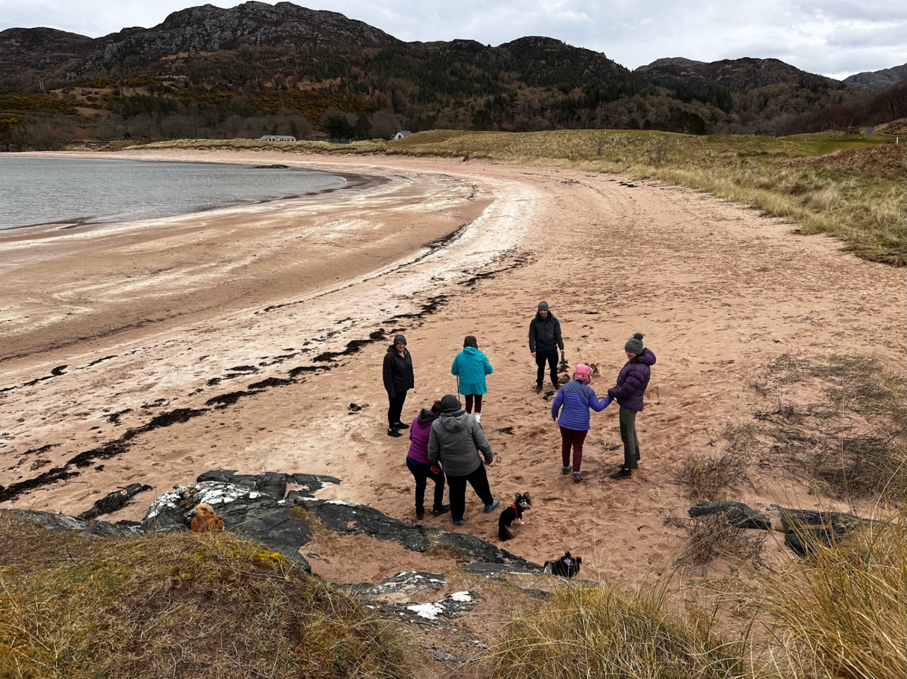 A group walking together along a quiet beach
