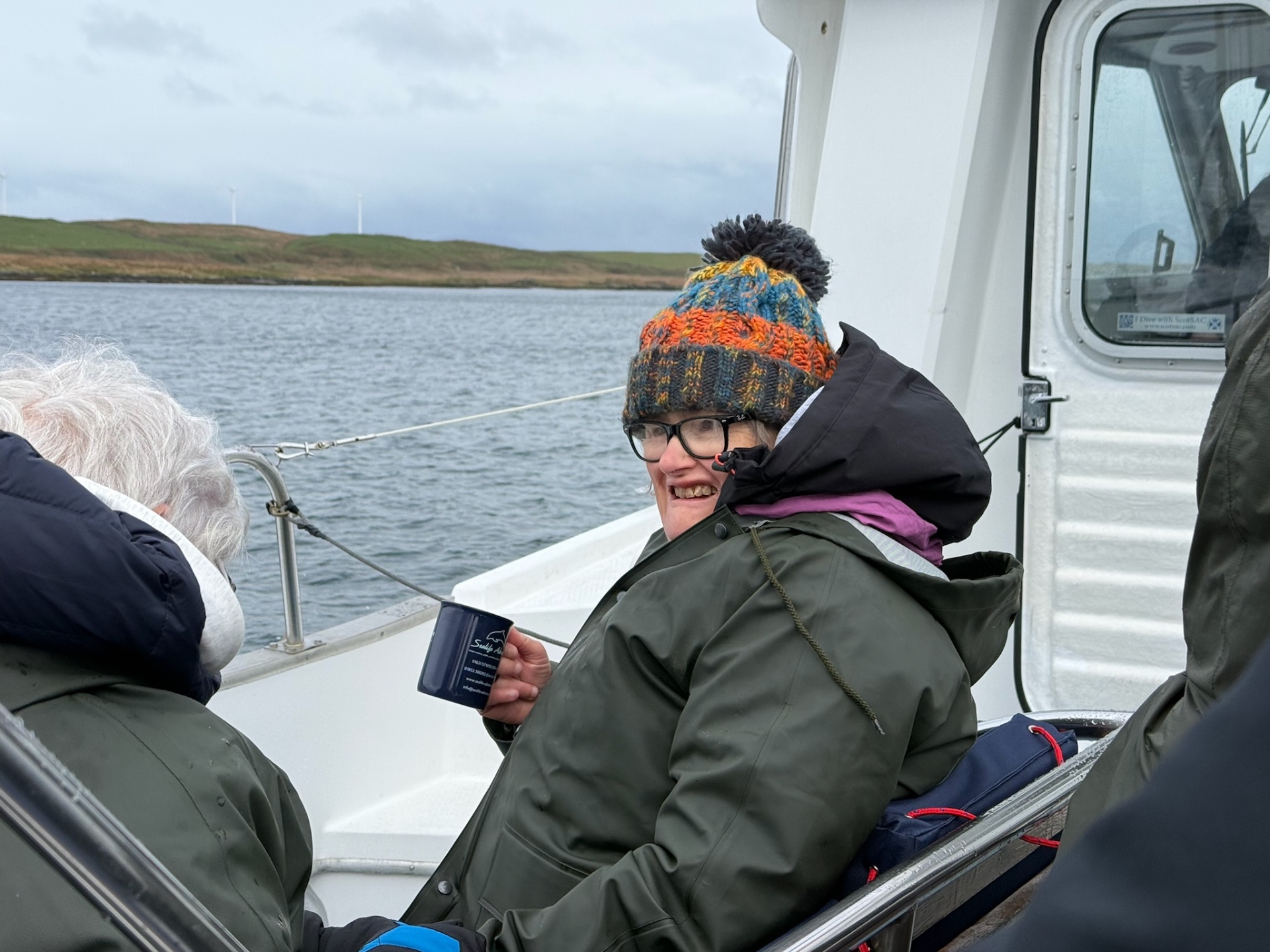 A resident enjoying a hot drink on a boat trip