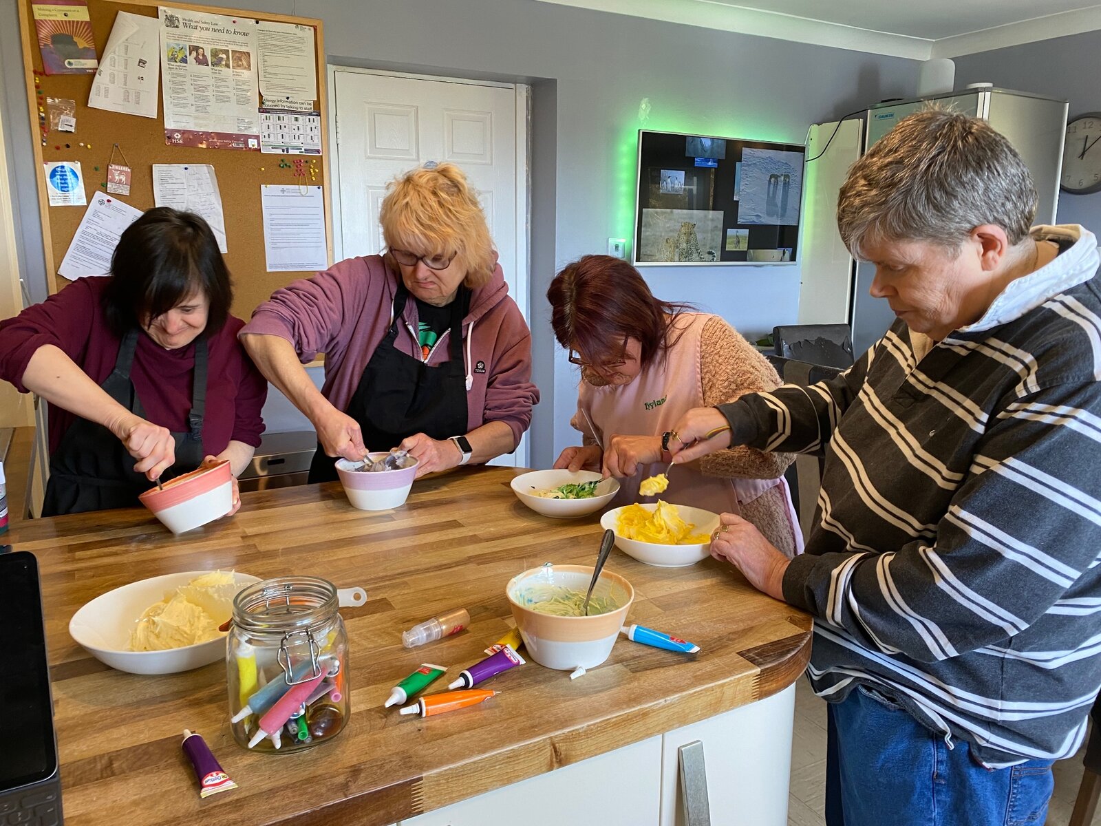 Residents and staff baking together at the kitchen worktop