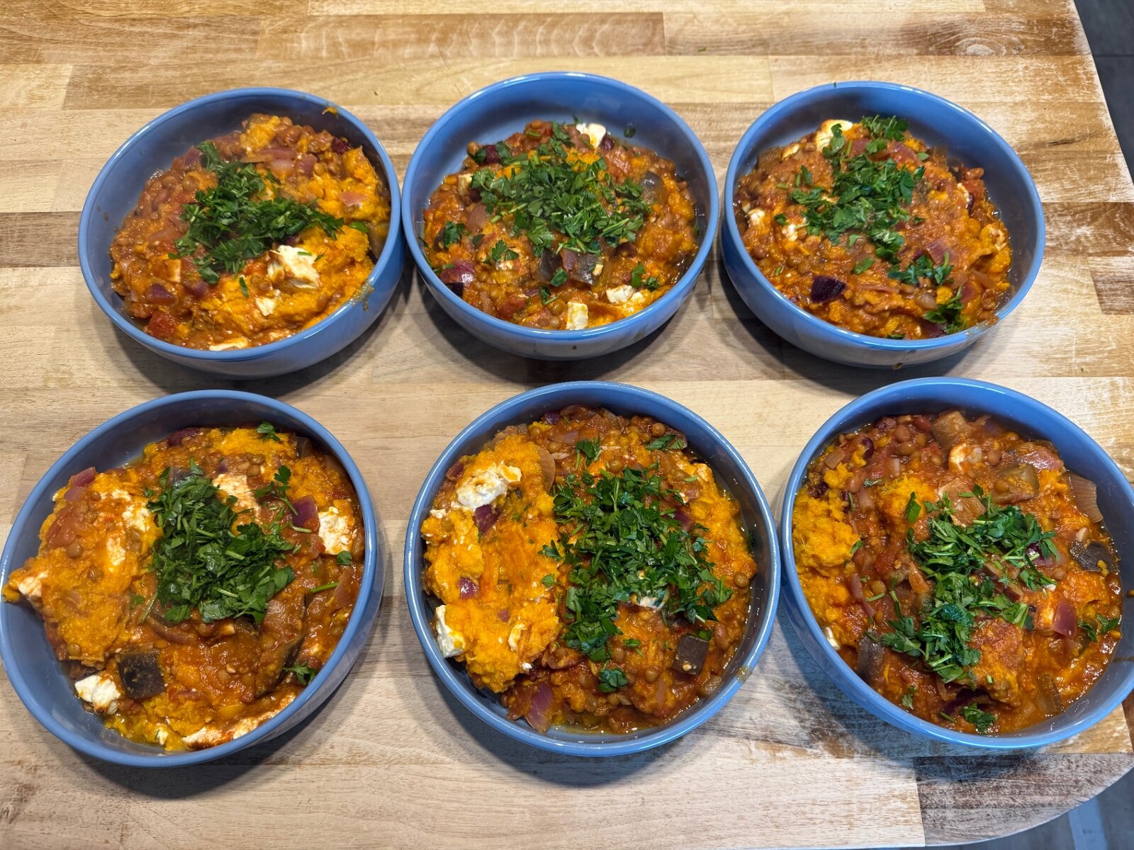 Bowls of a finished lentil and vegetable dish