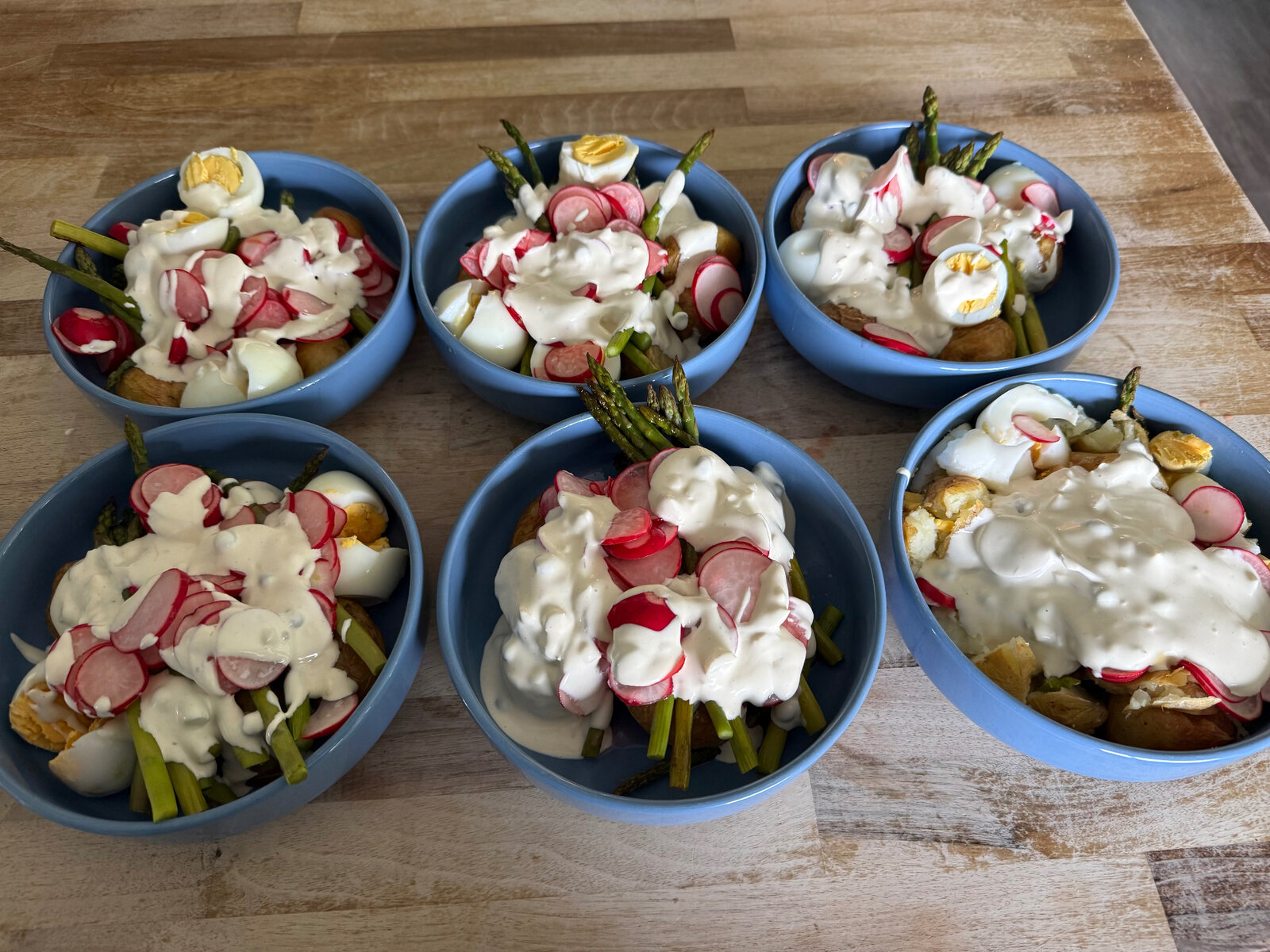 Bowls of potato, asparagus and egg salad