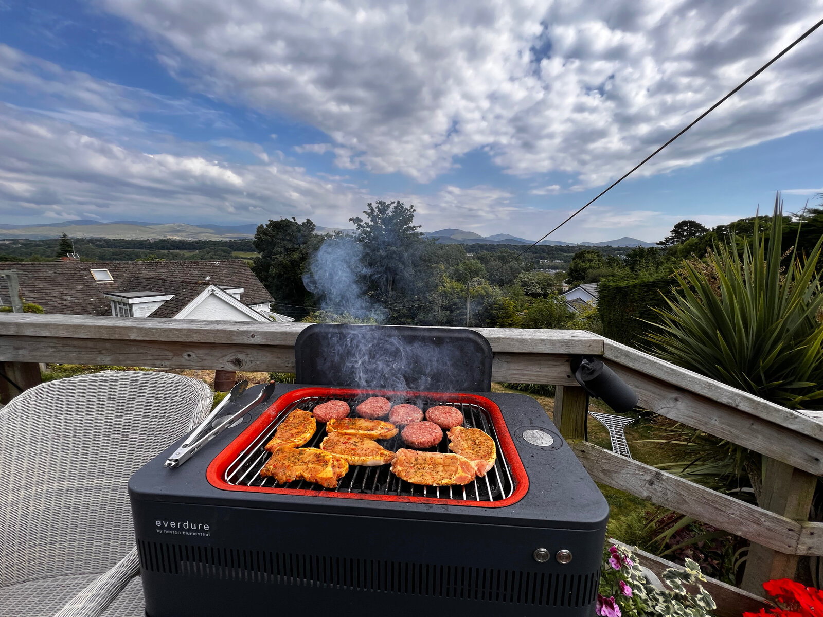 Outdoor barbecue food cooking with mountain views in the background